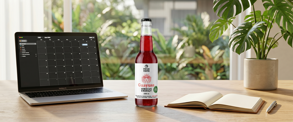 Guayusa i en flaske ved siden af en bærbar computer på et skrivebord – en praktisk guayusa-drink, der hjælper med at holde fokus på arbejdet.